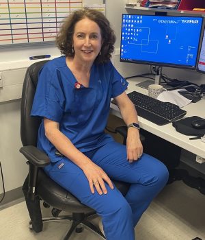 Resuscitation training instructor in clinical uniform seated in a healthcare setting