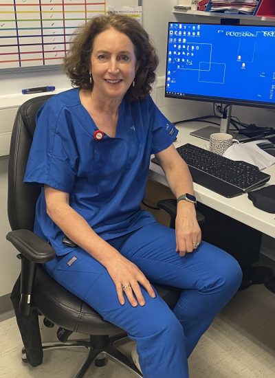 Resuscitation training instructor in clinical uniform seated in a healthcare setting